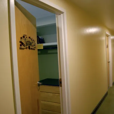 Photo of the dorm room hallway with door in the foreground slightly ajar.