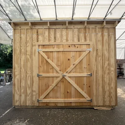 A garden shed with a shed roof and double doors.
