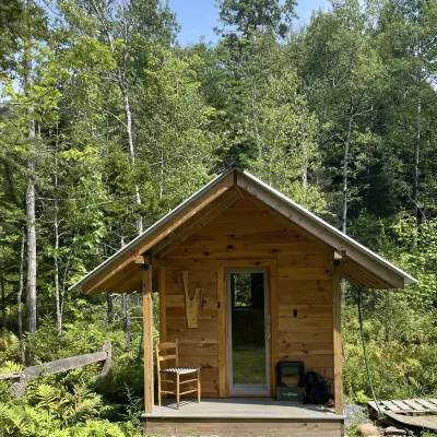 The front entrance of a suana with a gable roof and a porch.