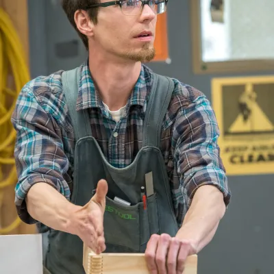 An instructor shows an example of finger joints at the table saw.