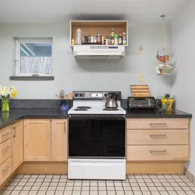 Shot of the student kitchen, with black concrete countertops and cabinets along the front and left walls. 