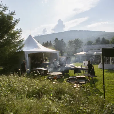Catering tents on the main lawn, with smoke rising from the nearby grills.