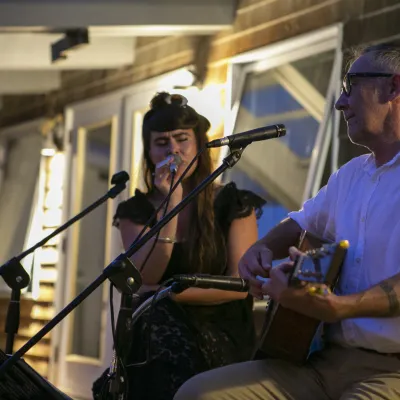 Brett Hughes and Kat Wright perform an acoustic set outside at night