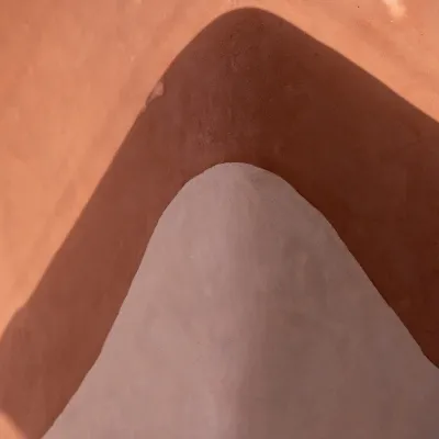 A plastered wall in two tones with shadow falling along the lines of the color blocks.