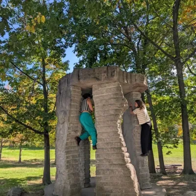 Students climb on an outdoor concrete structure