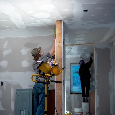 Two students mudding dry wall.