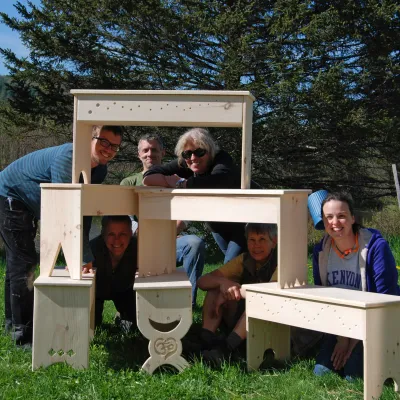 Students pose outside with their shaker benches stacked in a pyramid