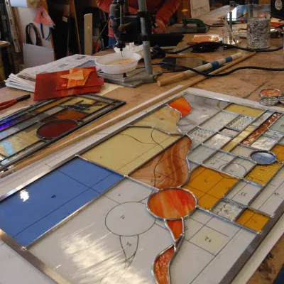 A stained glass panel being assembled