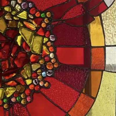 Close up shot of a red, orange and yellow stained glass panel.