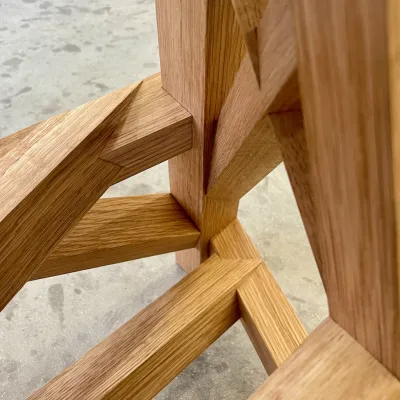 Close up of intricate wooden joinery with interlocking angled cuts.
