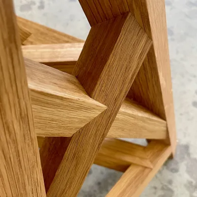Close up of intricate wooden joinery with interlocking angled cuts.