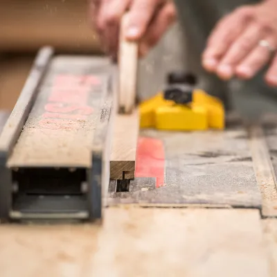 A close up photo of a student using a table saw
