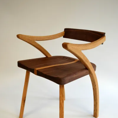 A two-toned wood chair pictured in a photo studio