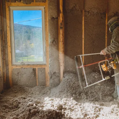 A person installing cellulose insulation.