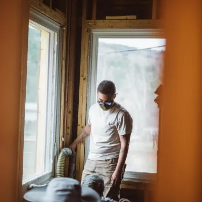 A person operating the hose for installing cellulose insulation.